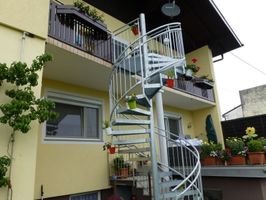 weiße Wendeltreppe bei Hausmauer