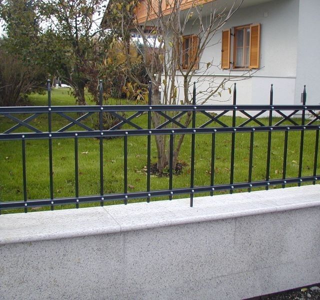 Zaun ums Grundstück aus Beton mit Metallelement- Streifen vespielt oben