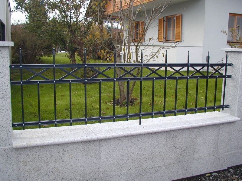 Zaun ums Grundstück aus Beton mit Metallelement- Streifen vespielt oben
