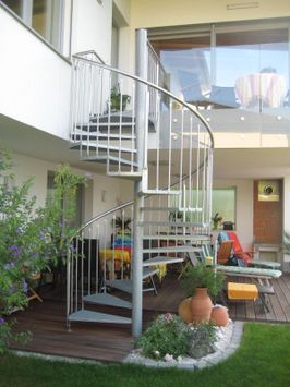 Wendeltreppe hellgrau im Garten in den ersten Stock zur Terasse