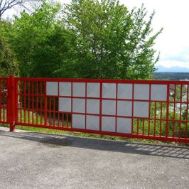 großes Einfahrtstor rot mit teilweisem Sichtschutz