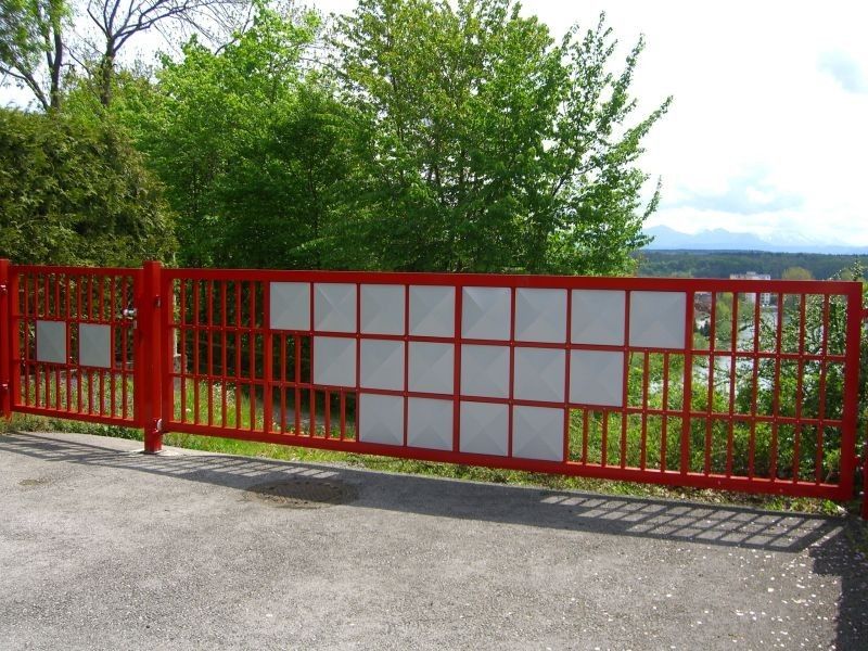 großes Einfahrtstor rot mit teilweisem Sichtschutz