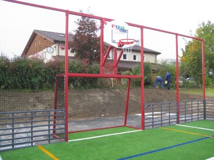 Rotes Gitter rund um den Fußballplatz mit Tor