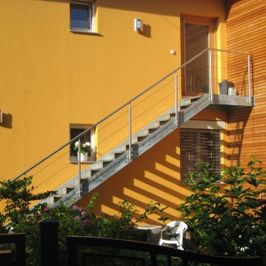 Außentreppe auf gelber Wand