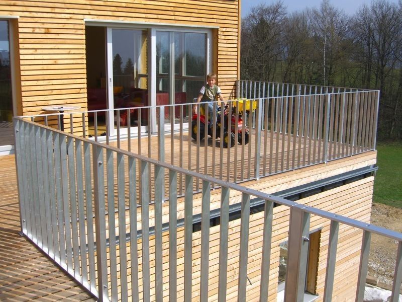 Geländer auf Holzterasse im Stockwerk bei einem Haus